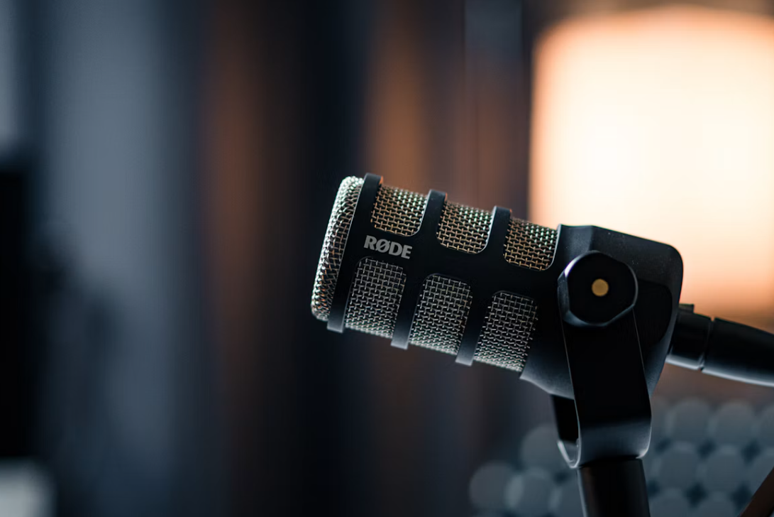 Close-up of a podcast microphone in warm studio lighting